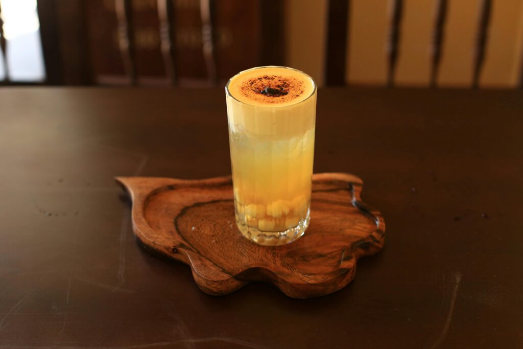 A delicious glass of Vietnamese egg coffee served on a wooden tray, captured in Hội An.