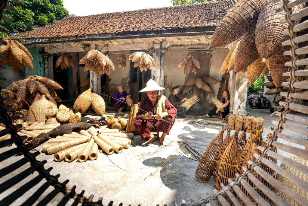 hoi-an-artisans-crafting-traditional- Hoi An artisans crafting traditional bamboo products in a tranquil Vietnamese village setting.