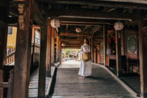 A woman in traditional dress on the historic Japanese Bridge in Hội An, Vietnam.